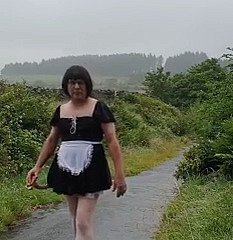 Femme de ménage travestie dans une voie publique sous dampen pluie